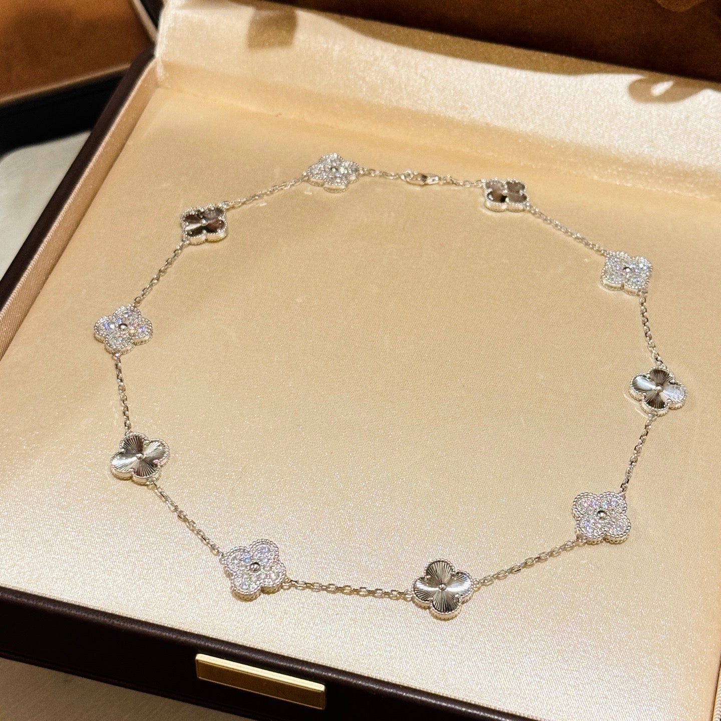 Laser-cut four-leaf clover necklace with interspersed diamonds and ten flowers