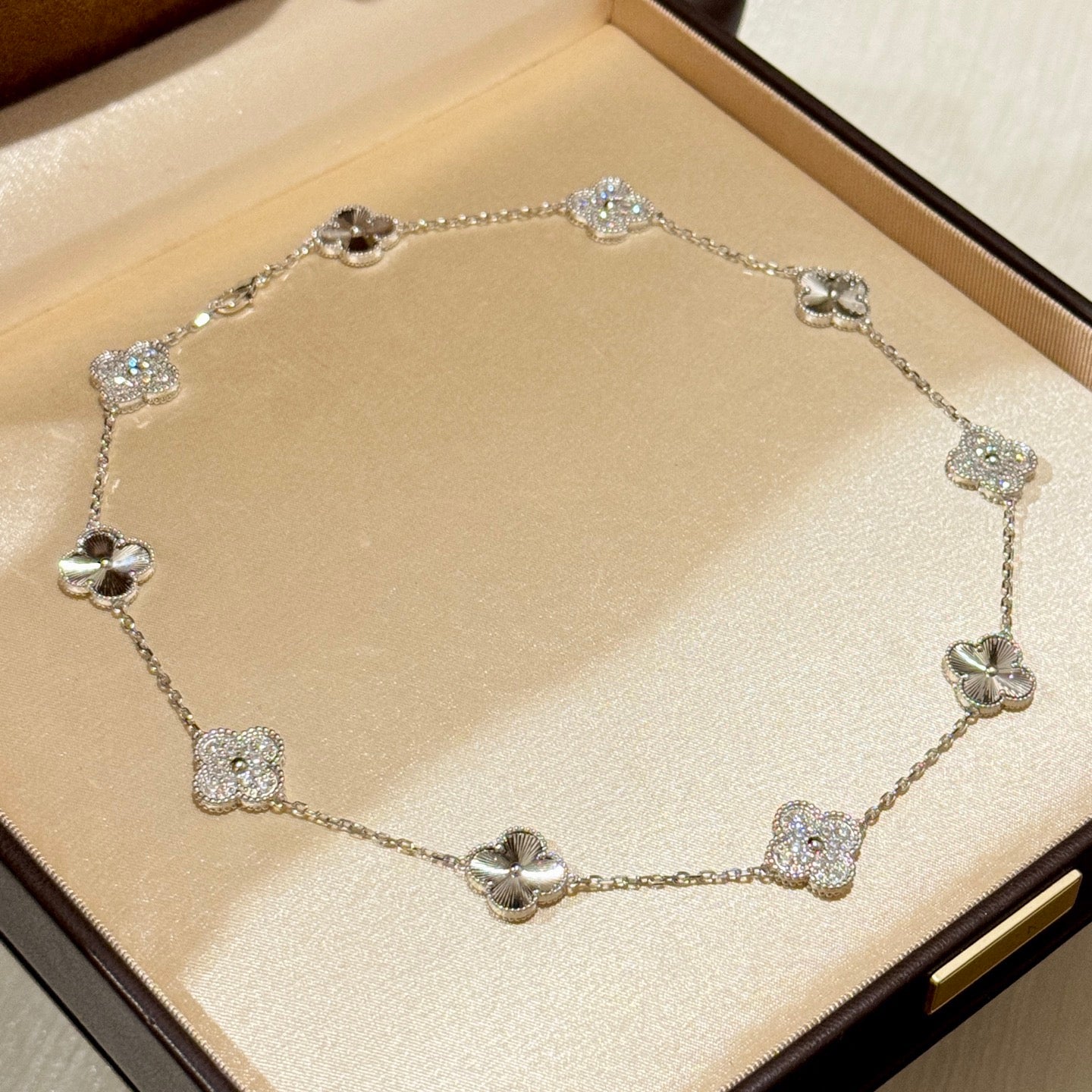 Laser-cut four-leaf clover necklace with interspersed diamonds and ten flowers