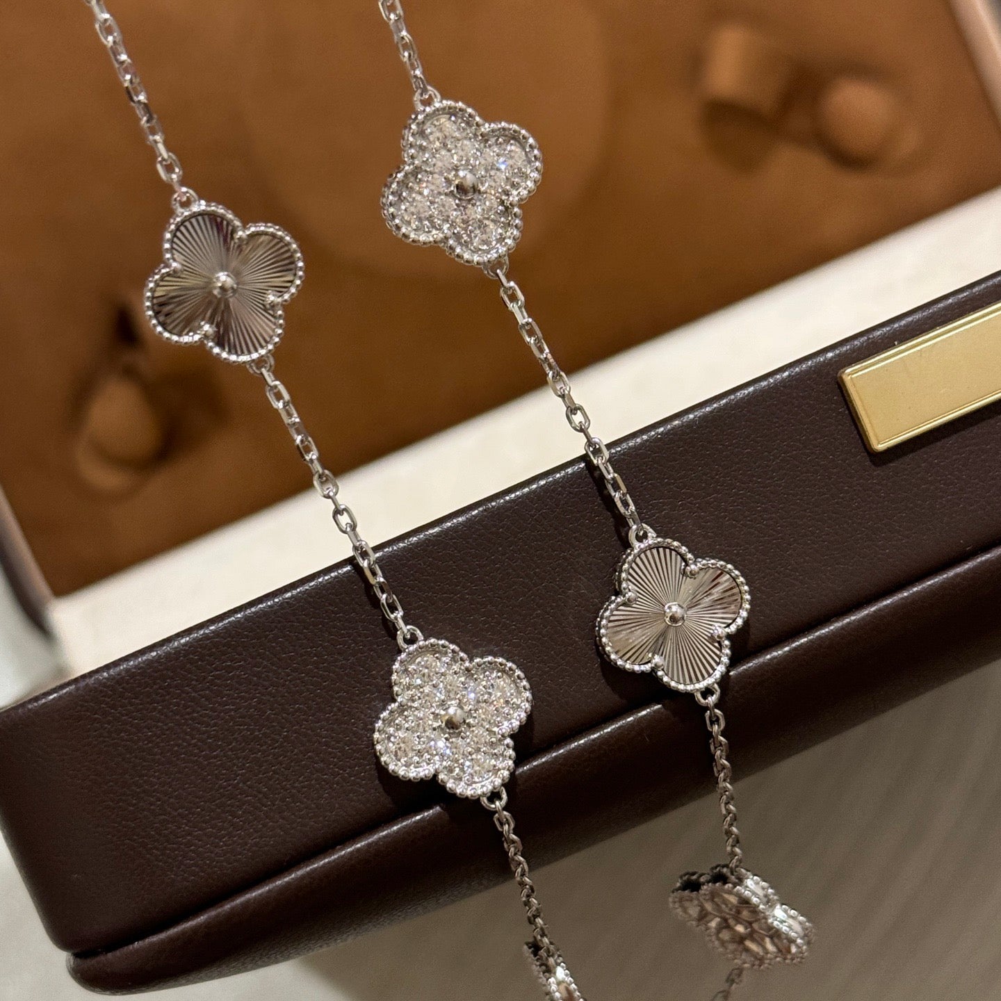 Laser-cut four-leaf clover necklace with interspersed diamonds and ten flowers