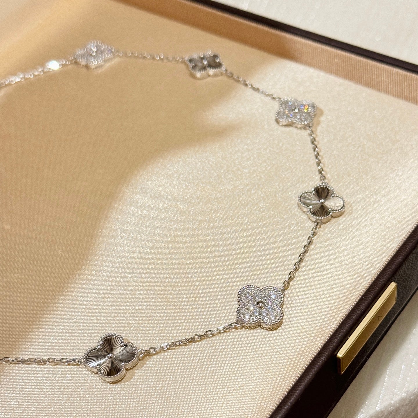 Laser-cut four-leaf clover necklace with interspersed diamonds and ten flowers